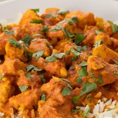 En skål med fluffigt ris toppad med saftig kyckling i en krämig, orange currysås. Strössel av färsk koriander ger en härlig touch till denna skolans kyckling curry.