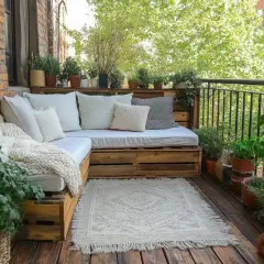 Przytulny balkon z sofą z palet i mnóstwem roślin. Idealne miejsce, by dowiedzieć się, jak osłonić balkon i stworzyć zieloną oazę.