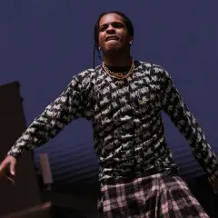 ASAP Rocky opener na scenie, w bluzie z nadrukiem i kratową spódnicą.
