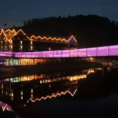 Widok na hotel z mostem oświetlonym na fioletowo, idealny na jedne z **ciekawe miejsca do 100 km od Katowic**.