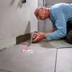 Man lägger fogbredd klinker 30x60. Plattor läggs noggrant med distanser för jämna fogar.