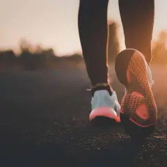 Scarpe da corsa al tramonto, un passo dopo l'altro per bruciare calorie camminata.