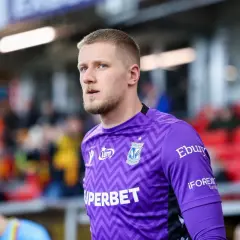Bartosz Mrozek, bramkarz Lecha Poznań, w fioletowej koszulce z charakterystycznym wzorem.