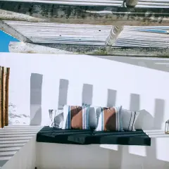 Comoda veranda senza permessi con cuscini a righe e lanterne.