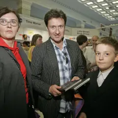 Kobieta w okularach, mężczyzna w marynarce w paski i chłopiec w garniturze.