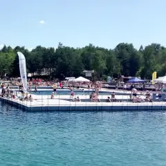 Ludzie odpoczywają i kąpią się na pomoście w Balatonie Trzebinia. Słoneczny dzień zachęca do relaksu nad wodą.