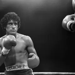 Salvador Sanchez, a legendary boxer, stands ready in the ring, his reach evident as he faces an opponent.
