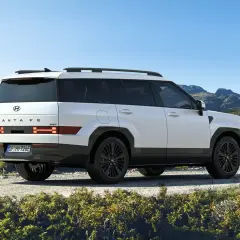 Biały Hyundai Santa Fe 2025 z czarnymi felgami na tle górskiego krajobrazu.