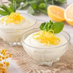 Delicioso mousse de limón con leche condensada, adornado con ralladura de limón y menta fresca.
