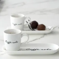 Eleganckie filiżanki z napisem "Caffè solo" i czekoladki na talerzykach. Idealny sposób, jak podawać kawę gościom.