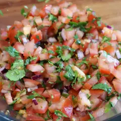 Świeża, kolorowa salsa pomidorowa z cebulą i kolendrą, gotowa do podania.