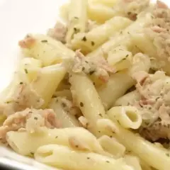 Macarrones con atún, un plato sencillo y delicioso. Pasta penne mezclada con atún desmenuzado y hierbas verdes.