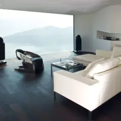 Modernes Wohnzimmer mit Panoramafenster, das eine atemberaubende Aussicht bietet. Ein weißes Ledersofa, ein futuristischer Sessel und zwei schlanke Lautsprecher ergänzen die minimalistische Einrichtung. Das Panoramafenster dekorieren wir hier mit der N...