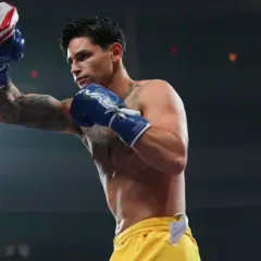 Ryan Garcia trains with a punching bag, his blue gloves a blur of motion.