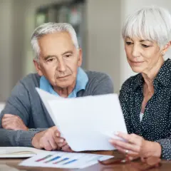 Älteres Paar prüft Dokumente. Sie überlegen, was ist besser: Altersteilzeit oder Rente mit 63?
