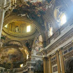 Interno della chiesa del Gesù, con affreschi barocchi sul soffitto, cupola e decorazioni dorate.