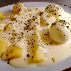 Jajka w sosie musztardowym z ziemniakami, posypane ziołami. Pyszne danie na obiad.