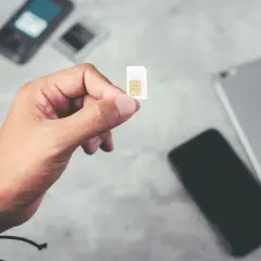 Dłoń trzyma kartę SIM, gotową do włożenia do telefonu. To idealne rozwiązanie dla osób szukających internetu na kartę bez umowy.