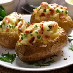 Patate ripiene al forno, dorate e croccanti, con un ripieno cremoso di formaggio, pancetta e erbe aromatiche.