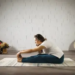 Mujer en postura de yoga Paschimottanasana, explorando el hatha significado de la calma y la conexión.