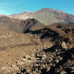 Paisaje volcánico árido visto desde el mirador de Samara, con montañas y conos de ceniza bajo un cielo azul.