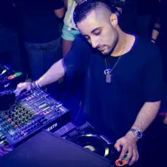 Un dj musica techno con cuffie mixa su console Pioneer, immerso nell'atmosfera di un club.
