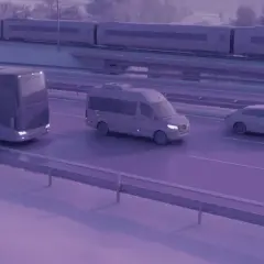 Zastanawiasz się, ile kosztuje bus do Francji? Na drodze widzimy autokar, busa i samochód, a w tle pociąg.