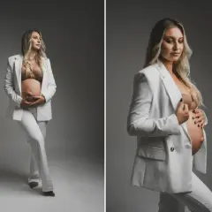 Elegancka sesja ciążowa w studio. Przyszła mama w białym garniturze czule obejmuje brzuszek.