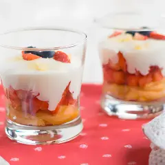 Delicioso tiramisú de fresa en capas, con bizcocho, fresas, crema y arándanos.