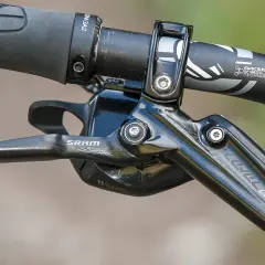 Close-up of a SRAM Level Ultimate brake lever on a mountain bike handlebar, ready for any trail.