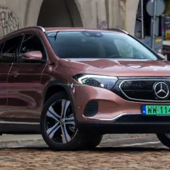 Różowy Mercedes EQA na tle graffiti.