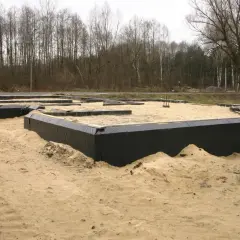 Fundament domu w piasku, zabezpieczony czarną folią, zapewnia prawidłową izolację fundamentów.