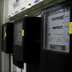 Liczniki przedpłatowe, jak doładować licznik? Na zdjęciu widać rząd czarnych liczników energii elektrycznej.