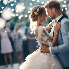 Para młoda tańczy przy świetle lampek. W tle goście weselni. Gotowa lista utworów do ZAIKS wesele.