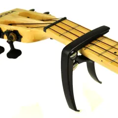 Czarny kapodaster do ukulele marki Moge na drewnianej podstrunnicy z widocznymi progami i strunami.