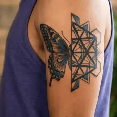 Tatuaż motyl meski na ramieniu, łączący delikatność natury z geometryczną precyzją.