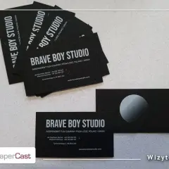Wizytówki "Brave Boy Studio" z białym napisem na czarnej kartce. Pokazują, jak wydrukować biały napis na czarnej kartce, tworząc elegancki efekt.