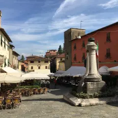 Piazza di Montecatini Alto, con tavolini all'aperto e un monumento. Un assaggio di cosa vedere a Montecatini Alto.