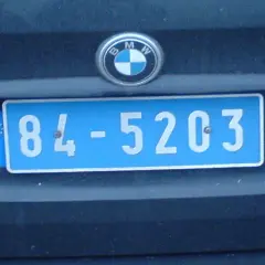 Plaque immatriculation bleue avec le sigle "F" et des étoiles européennes, typique de la France. Le numéro est 84-5203.