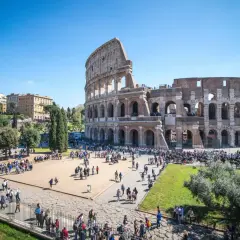 Le Colisée d'Italie, monument emblématique, accueille une foule de visiteurs sous un ciel bleu éclatant.