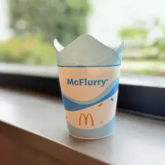 Pusty kubek po McFlurry, z logo McDonald's i falistym wzorem. Zastanawiasz się, ile McFlurry kcal ma Twój ulubiony smak?