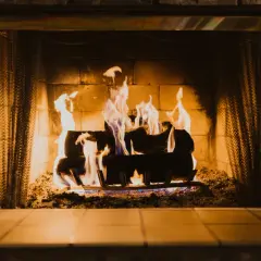 Un feu de cheminée crépite joyeusement, ses flammes dansantes projetant des signes chaleureux sur les briques.