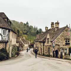 Kamienna uliczka w Cotswolds, z tradycyjnymi domami i zielenią.