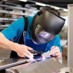 Uczeń na kursie spawacza TIG precyzyjnie łączy metalowe elementy, skupiony na pracy.