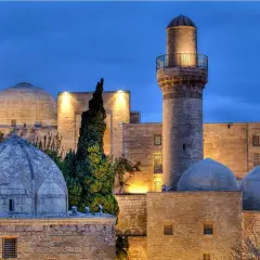 Meczet z minaretem i kopułami w Baku, symbol azerbejdżańskiej religii, oświetlony nocą.