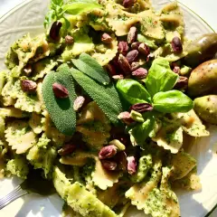 Farfalle condite con un saporito pesto di salvia, pistacchi e basilico fresco, guarnite con olive verdi.