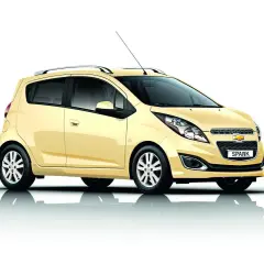 Żółty Chevrolet Spark, jeden z popularnych chevrolet modele, prezentuje się na białym tle.
