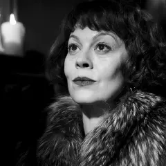 Helen McCrory, znana z roli Narcyzy Malfoy w Harry Potter, w eleganckim futrze i przy świecach.