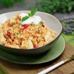 Schüssel mit Hähnchen und buntem Gemüse, garniert mit Joghurt und Minze. Ein köstliches Gericht, das zeigt, dass ist Couscous low carb möglich ist.
