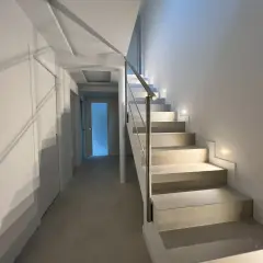 Iluminación peldaños escalera moderna, con luces empotradas que guían el camino.